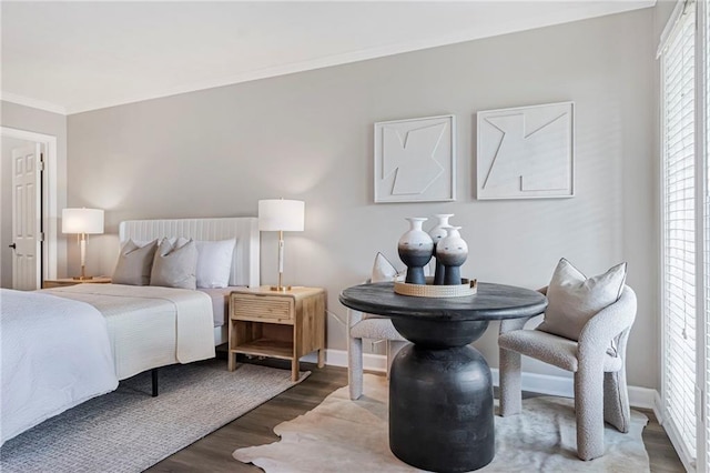 bedroom with wood finished floors, crown molding, and baseboards