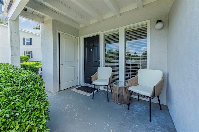 property entrance with stucco siding and a porch
