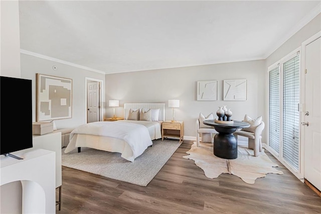 bedroom featuring crown molding, wood finished floors, and baseboards