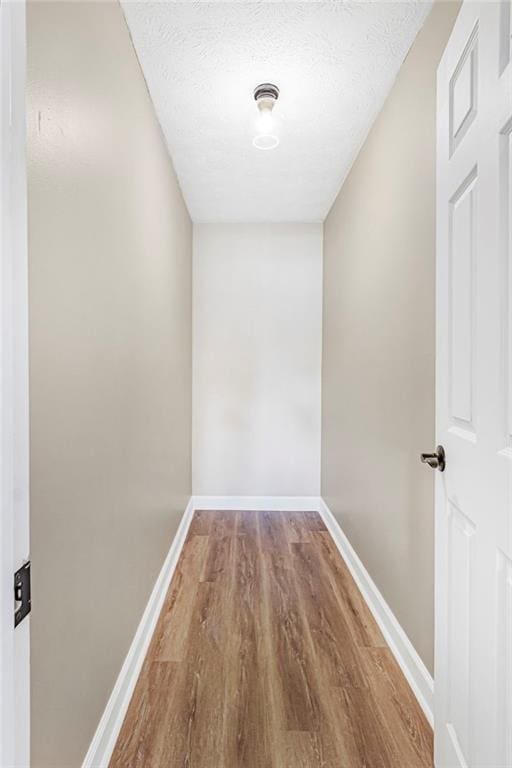 hall featuring wood finished floors and baseboards