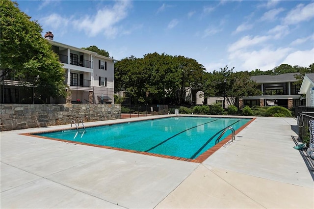 community pool featuring fence and a patio area