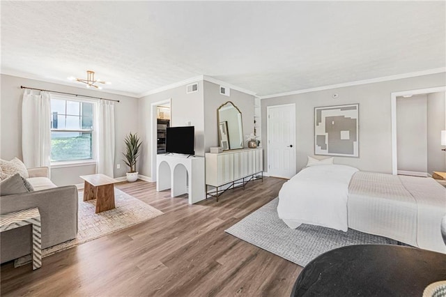 bedroom featuring wood finished floors, ornamental molding, baseboards, and a chandelier