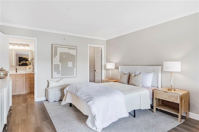 bedroom with baseboards, light wood finished floors, ornamental molding, and ensuite bathroom