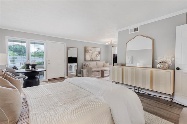 bedroom featuring wood finished floors, crown molding, and access to exterior