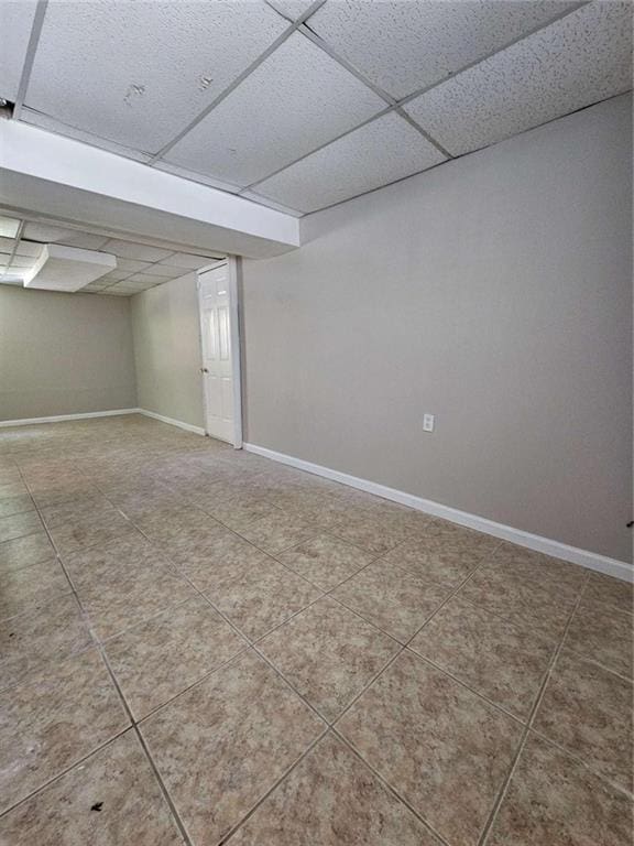 basement with tile patterned flooring and a drop ceiling