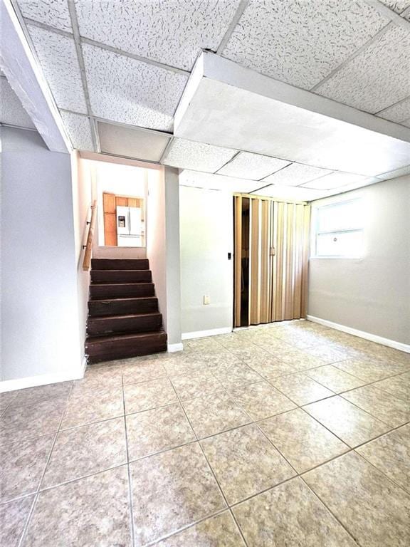 basement featuring a drop ceiling and tile patterned floors