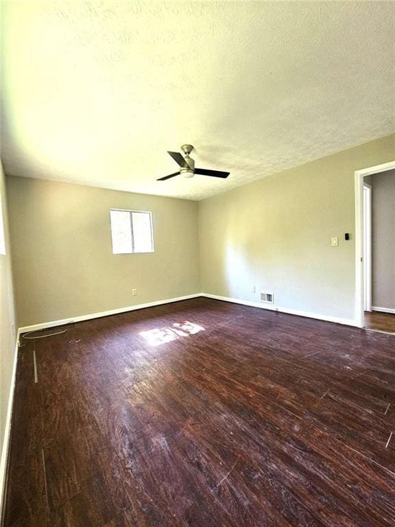 spare room featuring a textured ceiling, ceiling fan, and dark hardwood / wood-style flooring