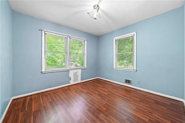 empty room featuring plenty of natural light and hardwood / wood-style floors