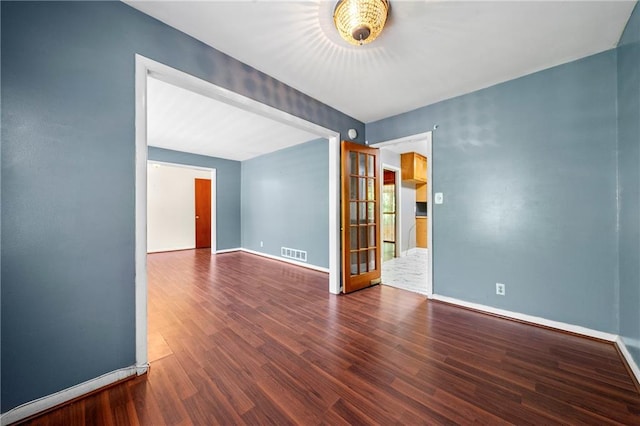 empty room with dark hardwood / wood-style flooring