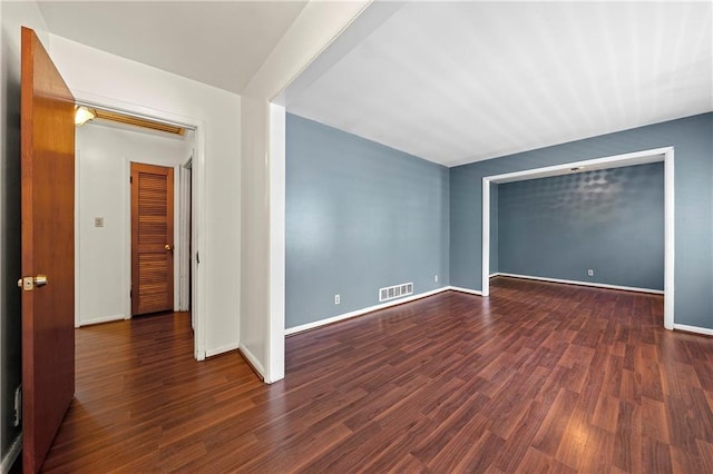 unfurnished room with dark wood-type flooring