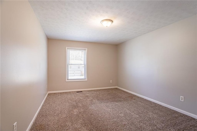 carpeted empty room featuring visible vents, baseboards, and a textured ceiling