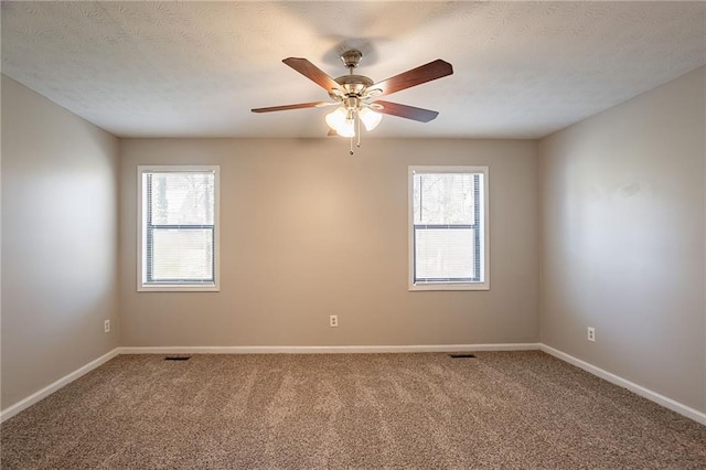 carpeted empty room with baseboards, plenty of natural light, a textured ceiling, and ceiling fan