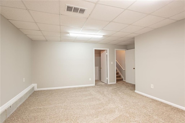 spare room with visible vents, baseboards, stairway, carpet flooring, and a paneled ceiling