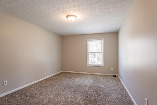 carpeted empty room featuring a textured ceiling and baseboards