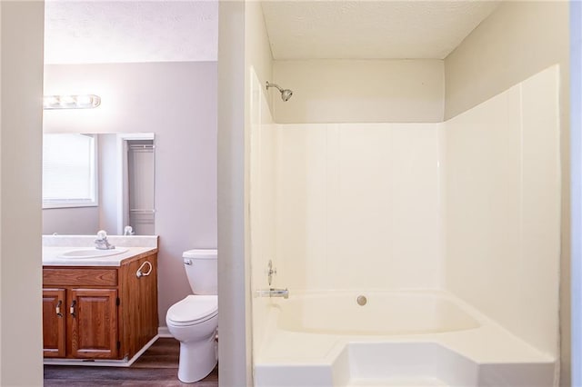 full bath with a textured ceiling, toilet, vanity, and wood finished floors