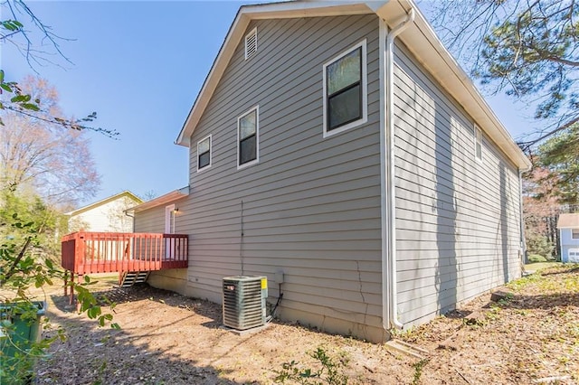 view of side of property featuring cooling unit and a wooden deck