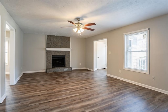 unfurnished living room featuring dark wood-style floors, a textured ceiling, baseboards, and ceiling fan