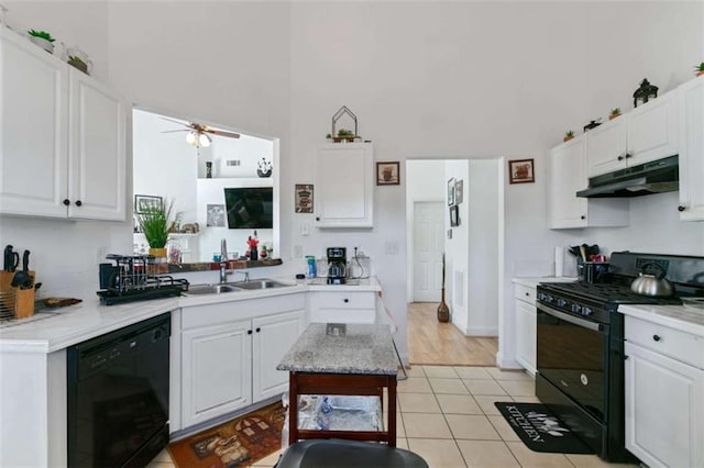 kitchen with white cabinets, a high ceiling, and black appliances