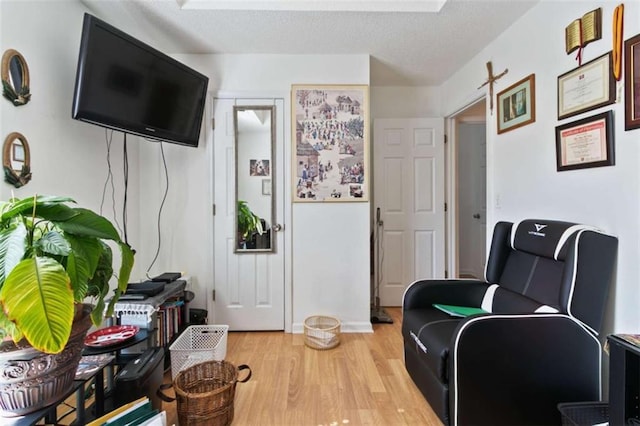 sitting room with a textured ceiling and light wood-type flooring