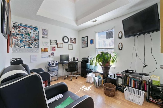 office space featuring a raised ceiling and hardwood / wood-style floors