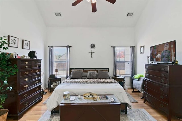 bedroom with ceiling fan, high vaulted ceiling, and light hardwood / wood-style flooring