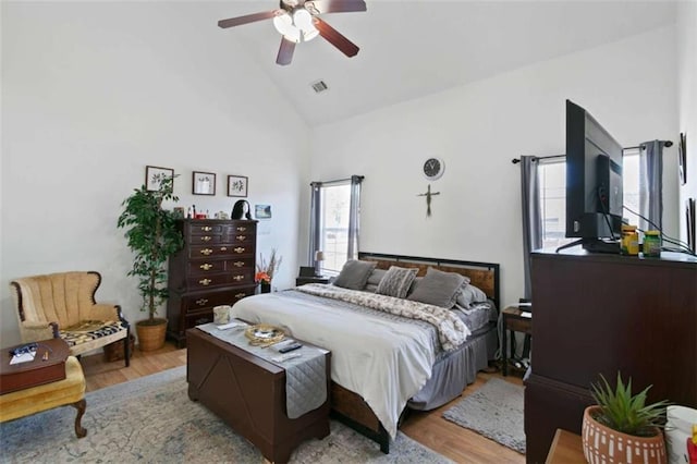 bedroom featuring light hardwood / wood-style flooring, high vaulted ceiling, and ceiling fan