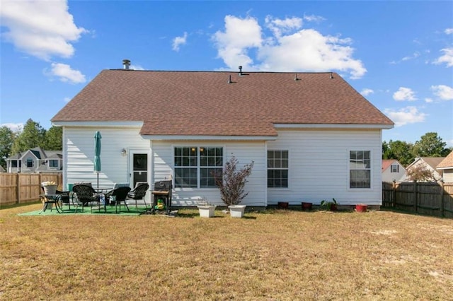 rear view of property with a yard and a patio