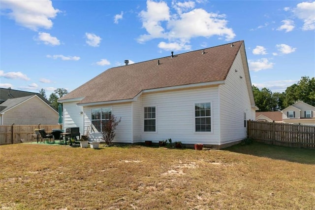 rear view of property featuring a patio and a yard