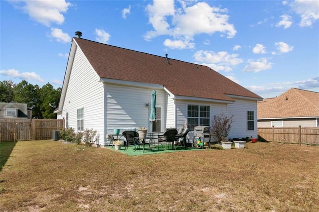 rear view of house featuring central AC, a patio, and a lawn