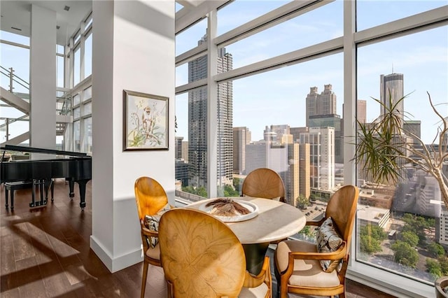 living area with a towering ceiling, a wall of windows, and dark hardwood / wood-style floors