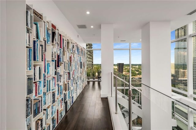 corridor with floor to ceiling windows and dark hardwood / wood-style floors