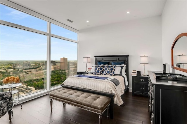 bedroom with floor to ceiling windows and dark hardwood / wood-style floors