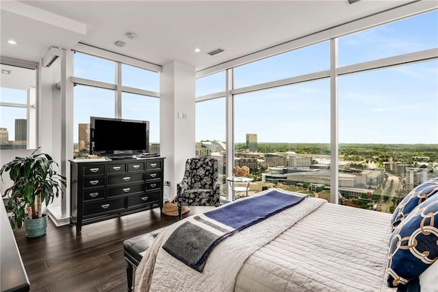 bedroom with a wall of windows and dark hardwood / wood-style flooring