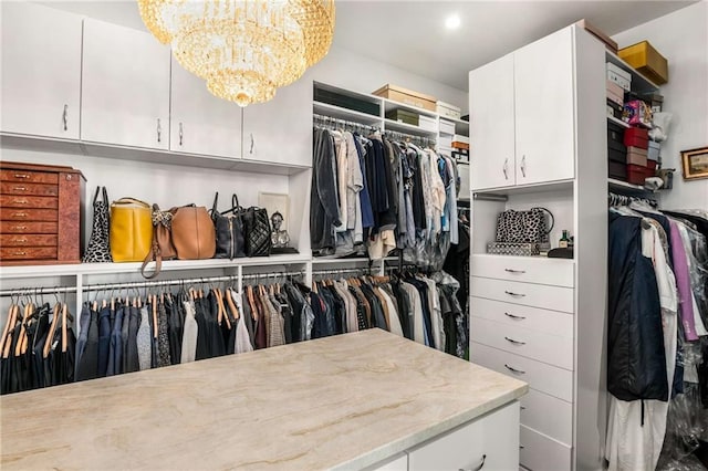 spacious closet featuring a chandelier