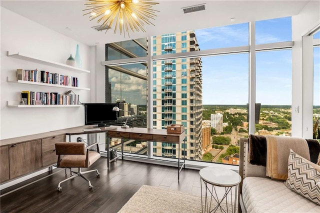 office space featuring a notable chandelier, a wall of windows, wood-type flooring, and baseboard heating