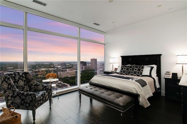 bedroom featuring expansive windows and hardwood / wood-style floors