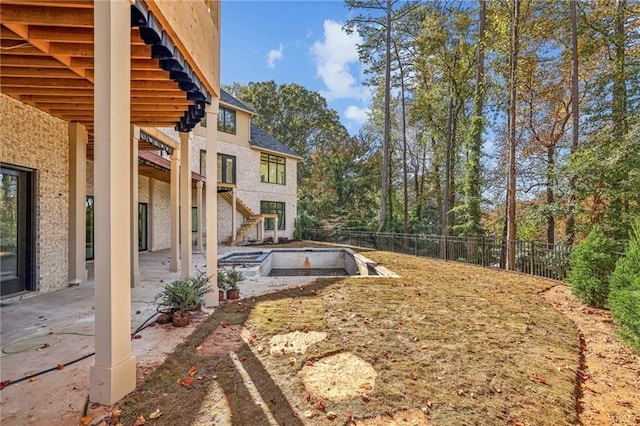 view of yard featuring fence, a patio, and stairs