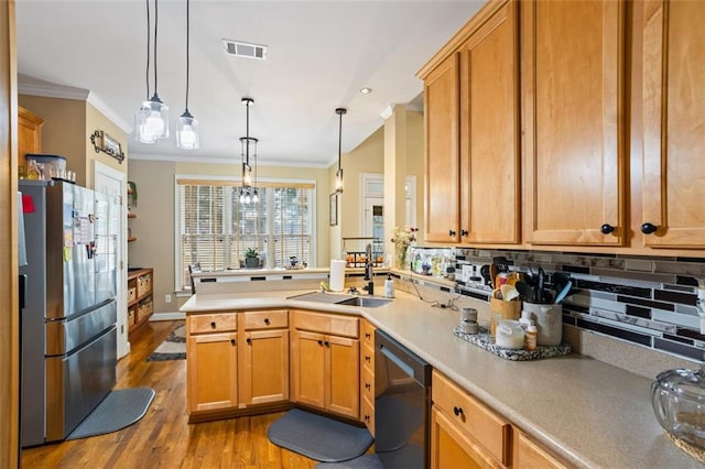 kitchen featuring ornamental molding, a sink, freestanding refrigerator, a peninsula, and dishwasher