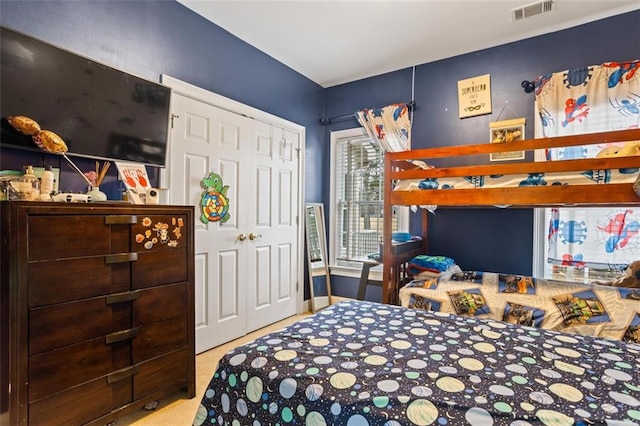 carpeted bedroom with visible vents and a closet