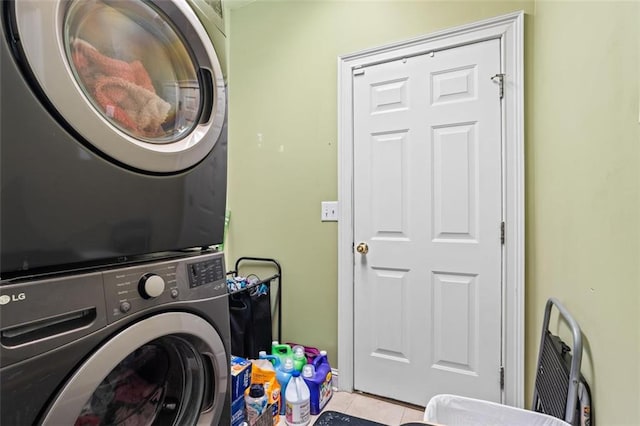 washroom featuring tile patterned floors, laundry area, and stacked washer / dryer