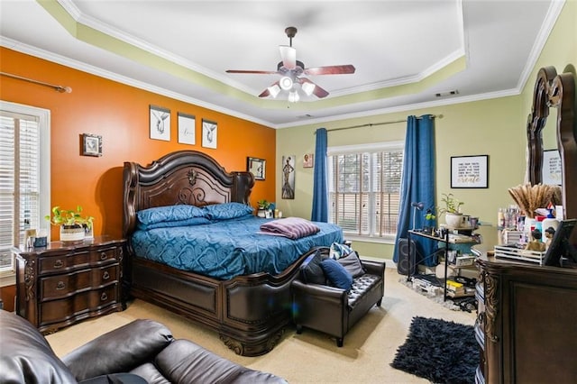 bedroom with a tray ceiling, carpet flooring, and ornamental molding