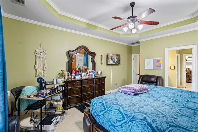 bedroom featuring a tray ceiling, visible vents, and ornamental molding