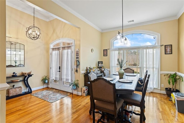 dining area featuring ornamental molding, wood finished floors, baseboards, and a chandelier