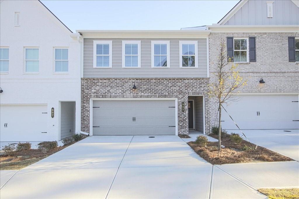 905 Agate Ln, Lawrenceville, GA 30043 - view of property with brick siding, concrete driveway, and a garage