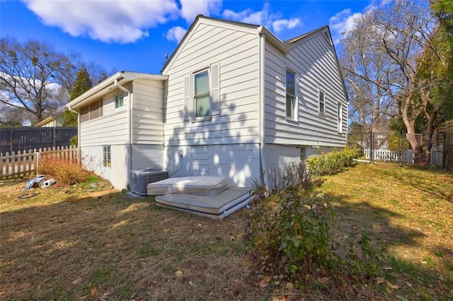 view of side of property featuring a lawn and central air condition unit