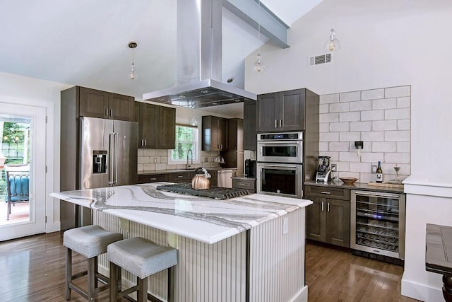 225 Jayne Ellen Way, Alpharetta, GA 30009 - kitchen with beverage cooler, island exhaust hood, appliances with stainless steel finishes, high vaulted ceiling, and decorative backsplash