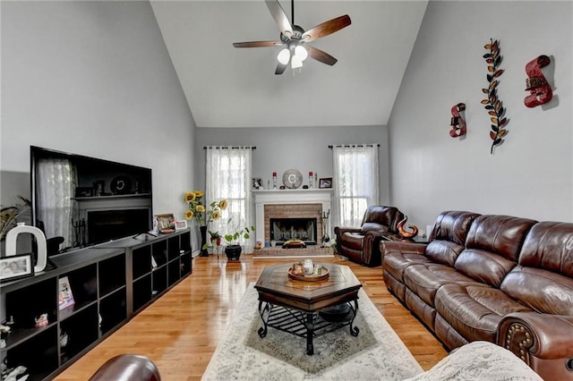 living room with hardwood / wood-style flooring, a brick fireplace, and a healthy amount of sunlight