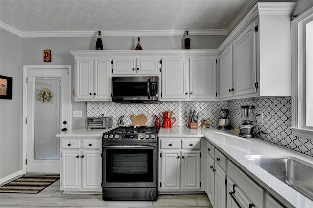 kitchen with crown molding, appliances with stainless steel finishes, and white cabinets