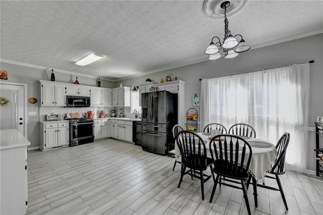 dining room with sink, crown molding, and a notable chandelier