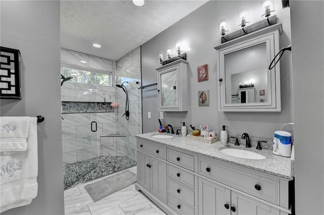 bathroom with vanity, a textured ceiling, and walk in shower